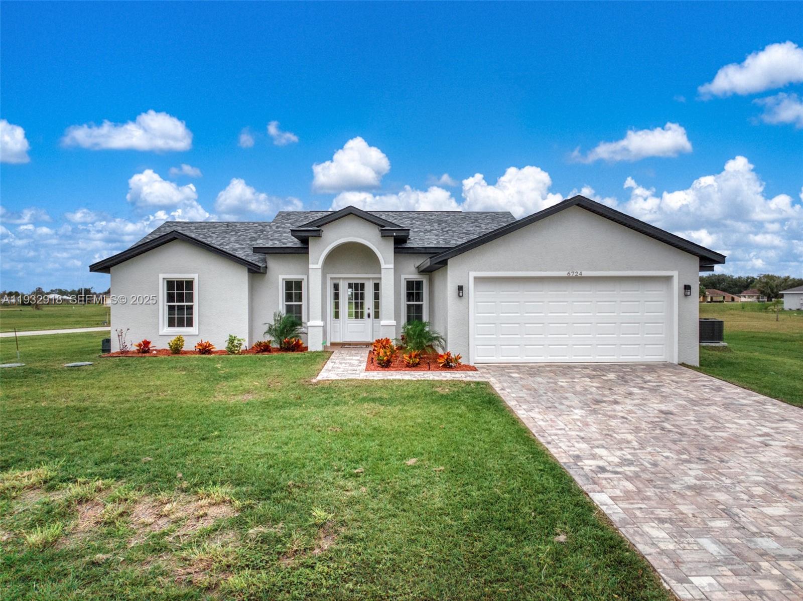 A single-story house with a white stucco exterior, gray shingled roof, and a paved driveway — 6724 Heavitree DR, Sebring FL 33876, SEBRING, FL