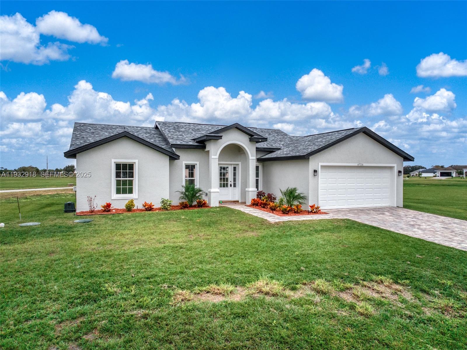 A single-story house with a gray stucco exterior, a two-car garage, and a paved driveway — 6724 Heavitree DR, Sebring FL 33876, SEBRING, FL