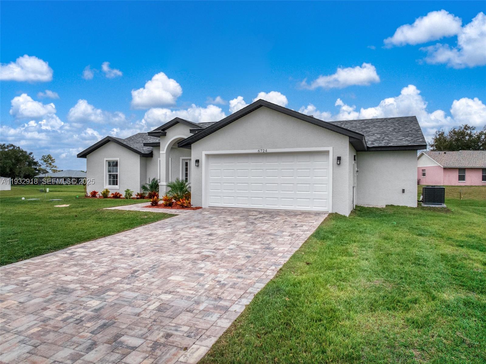 A single-story house with a white stucco exterior, a paved driveway, and a two-car garage — 6724 Heavitree DR, Sebring FL 33876, SEBRING, FL