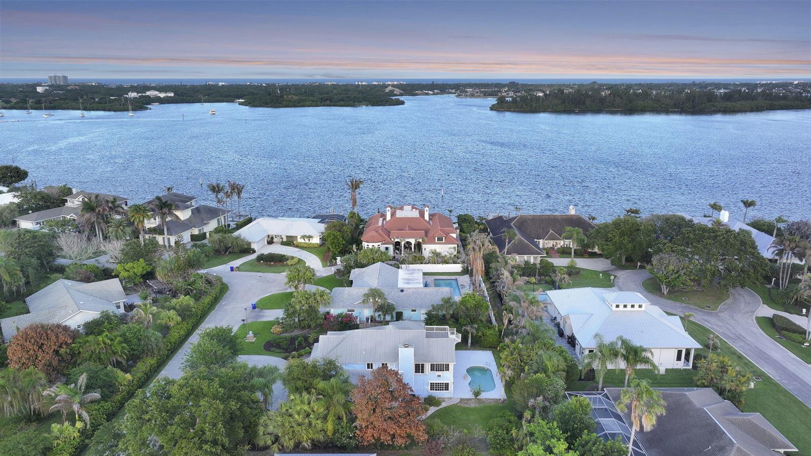 An aerial view of several waterfront houses with swimming pools and lush landscaping along a bay — 23 Sea Gull Place, Vero Beach FL 32960, VERO BEACH, FL