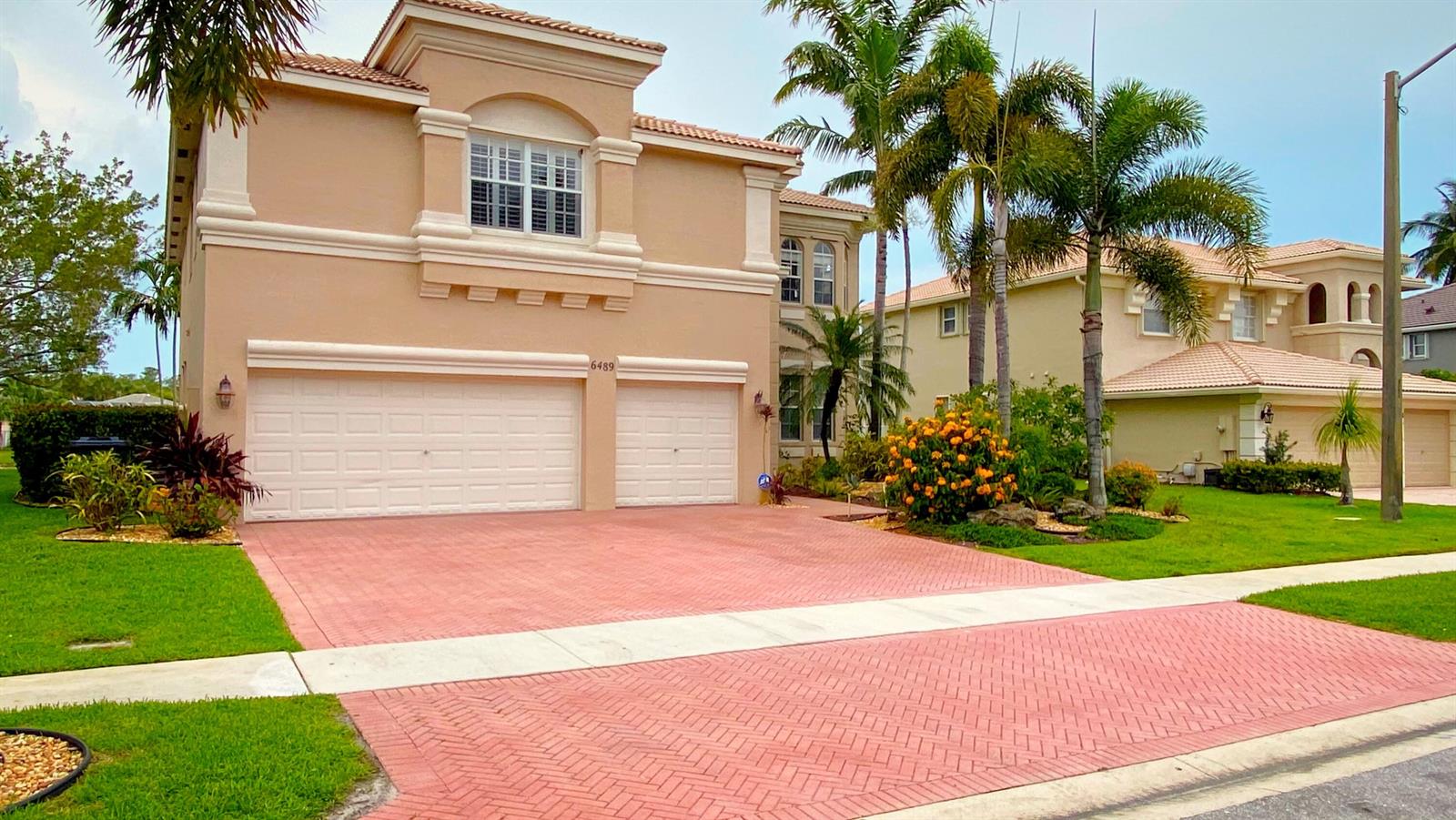 A two-story beige house with a red paver driveway and a three-car garage — 6489 Marbletree Lane, Lake Worth FL 33467, LAKE WORTH, FL