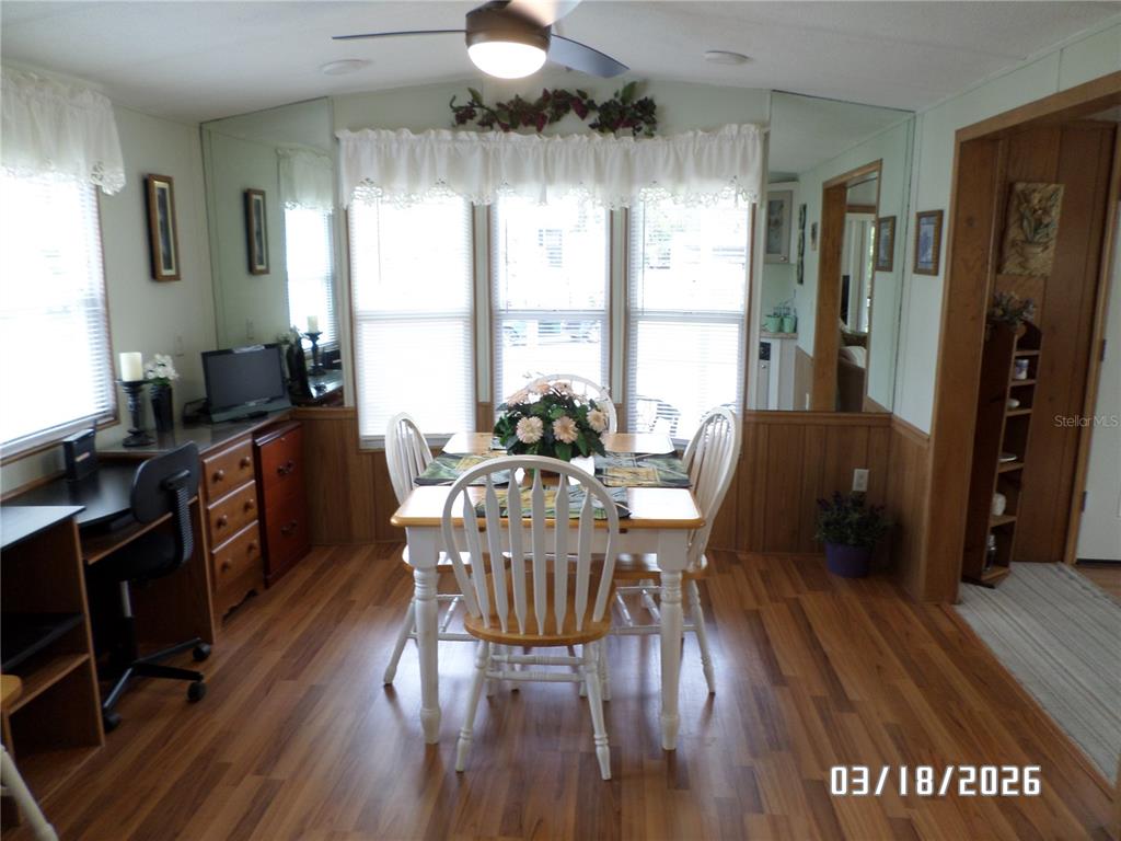 A dining area features a wooden table, white chairs, wood-look flooring, and mirrored walls — 37 APPALOOSA TRAIL, LAKE WALES, FL