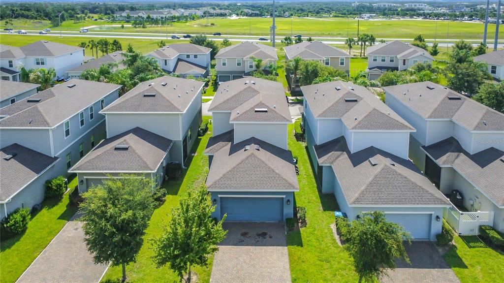 An aerial view shows a suburban neighborhood with several two-story houses and paved driveways — 5754 SURPRISE LILY DRIVE, WINTER GARDEN, FL