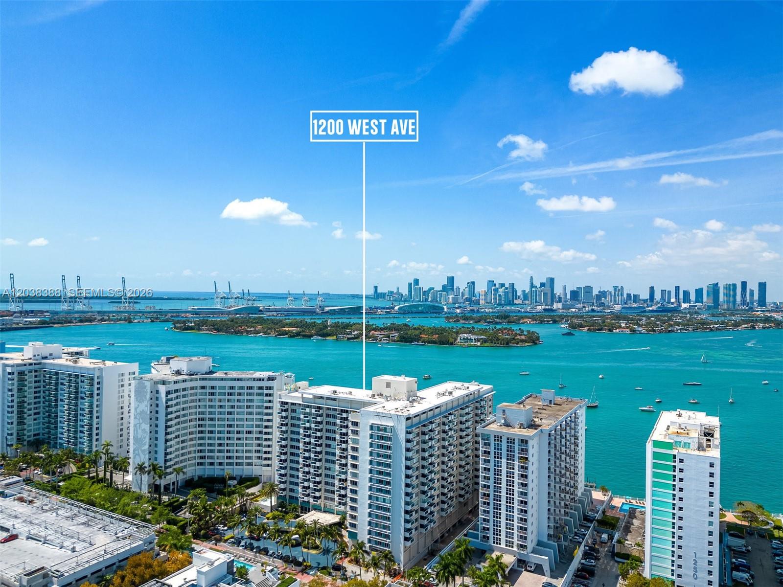 An aerial view shows several high-rise residential buildings situated along a turquoise waterfront — 1200 West Ave # 312, Miami Beach FL 33139, MIAMI BEACH, FL