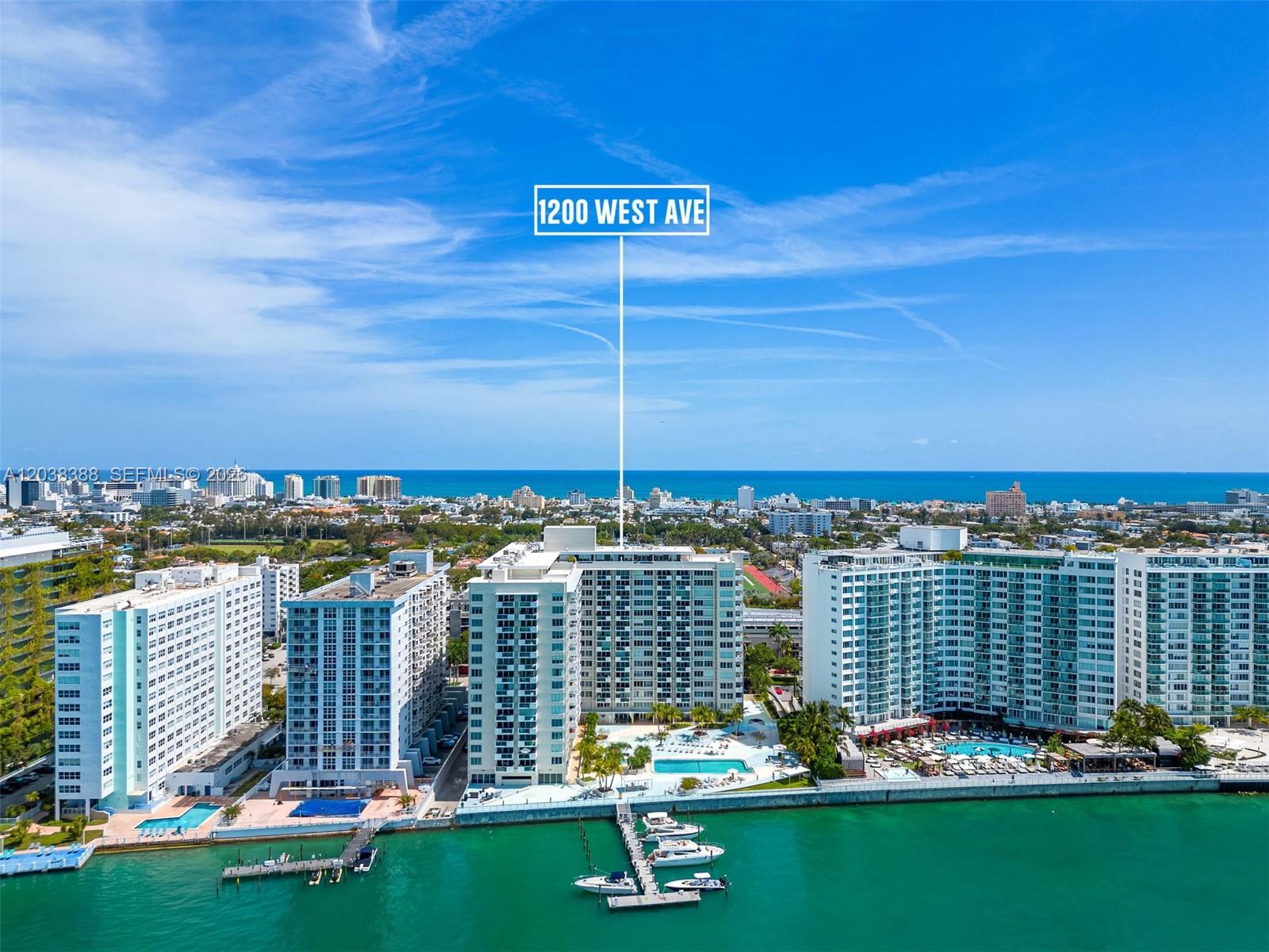 An aerial view shows several waterfront high-rise apartment buildings with pools and a boat dock — 1200 West Ave # 312, Miami Beach FL 33139, MIAMI BEACH, FL
