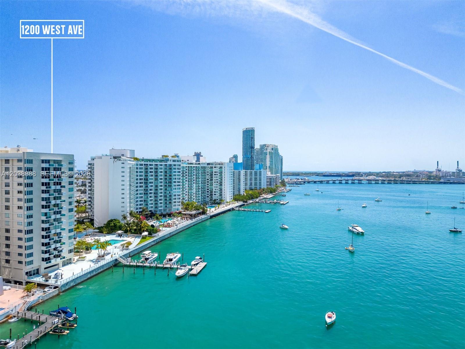 An aerial view shows high-rise residential buildings along a waterfront with boats and a pier — 1200 West Ave # 312, Miami Beach FL 33139, MIAMI BEACH, FL