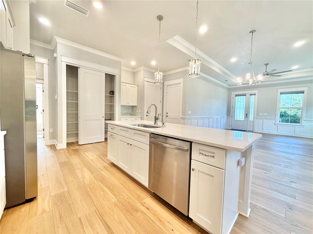 A kitchen with white cabinets, a stainless steel dishwasher, and a large island with seating — 2537 NW 48TH TERRACE, GAINESVILLE, FL