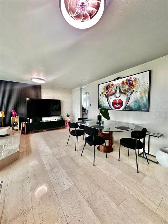 A dining area with a glass table and black chairs sits next to a living room — 1261 LUIS VIGOREAUX AVENUE UNIT 18D, GUAYNABO, PR