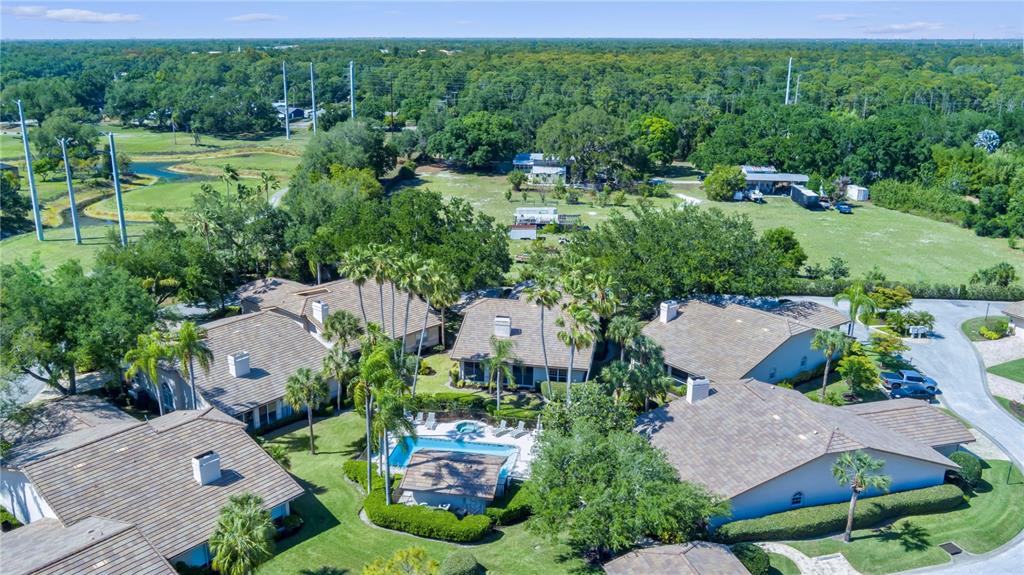 An aerial view shows several residential buildings with tiled roofs surrounding a central swimming pool — 4424 HIGHLAND PARK UNIT 5, SARASOTA, FL