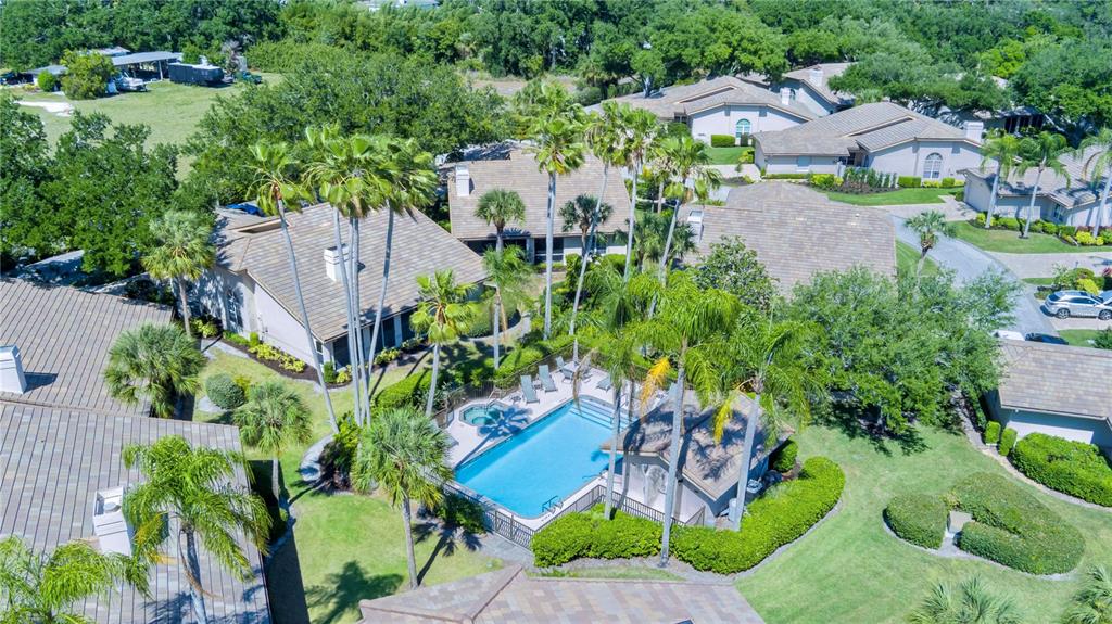 An aerial view shows a swimming pool and spa surrounded by palm trees and houses — 4424 HIGHLAND PARK UNIT 5, SARASOTA, FL