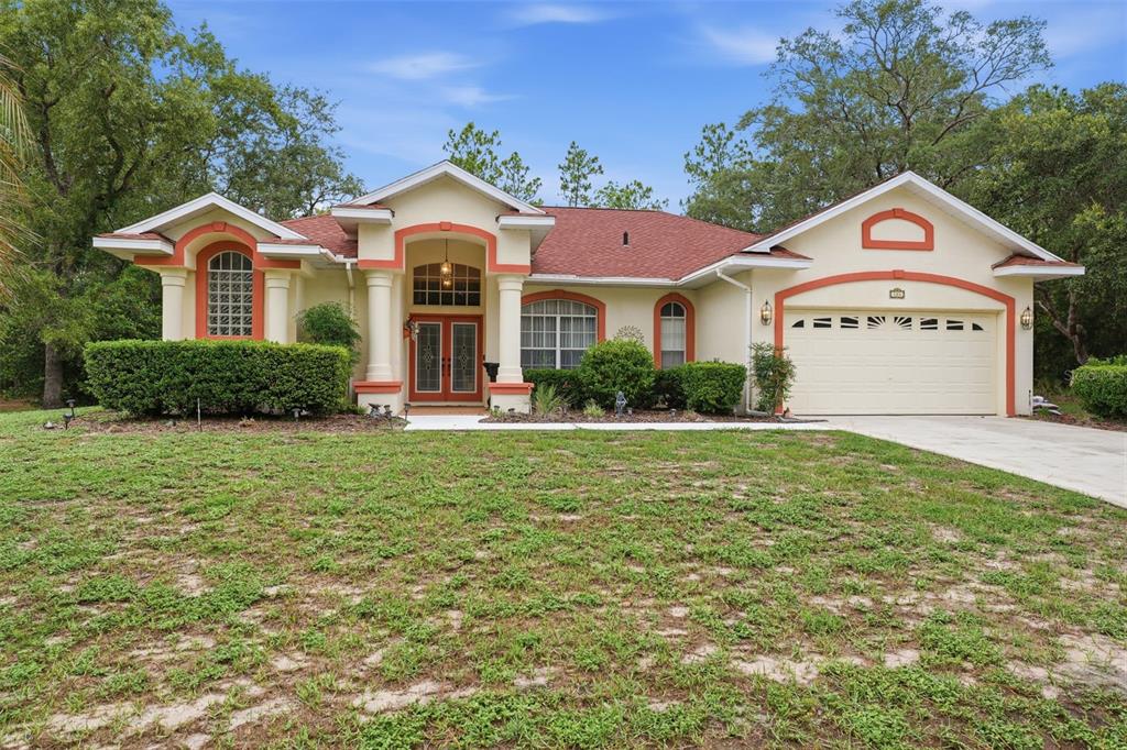 A single-story house with a red roof, orange trim, and a two-car garage — 184 PINE STREET, HOMOSASSA, FL