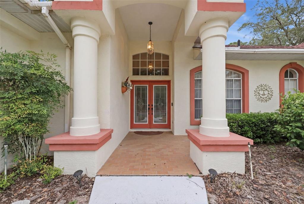 A front entrance features a brick porch, double doors, and two large white columns — 184 PINE STREET, HOMOSASSA, FL