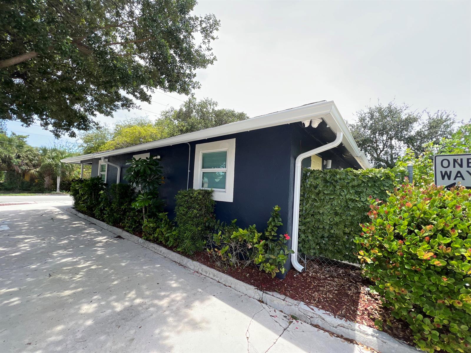 A dark blue exterior wall of a building features white trim, windows, and landscaping — 601 NW 2nd Street, Delray Beach FL 33444, DELRAY BEACH, FL
