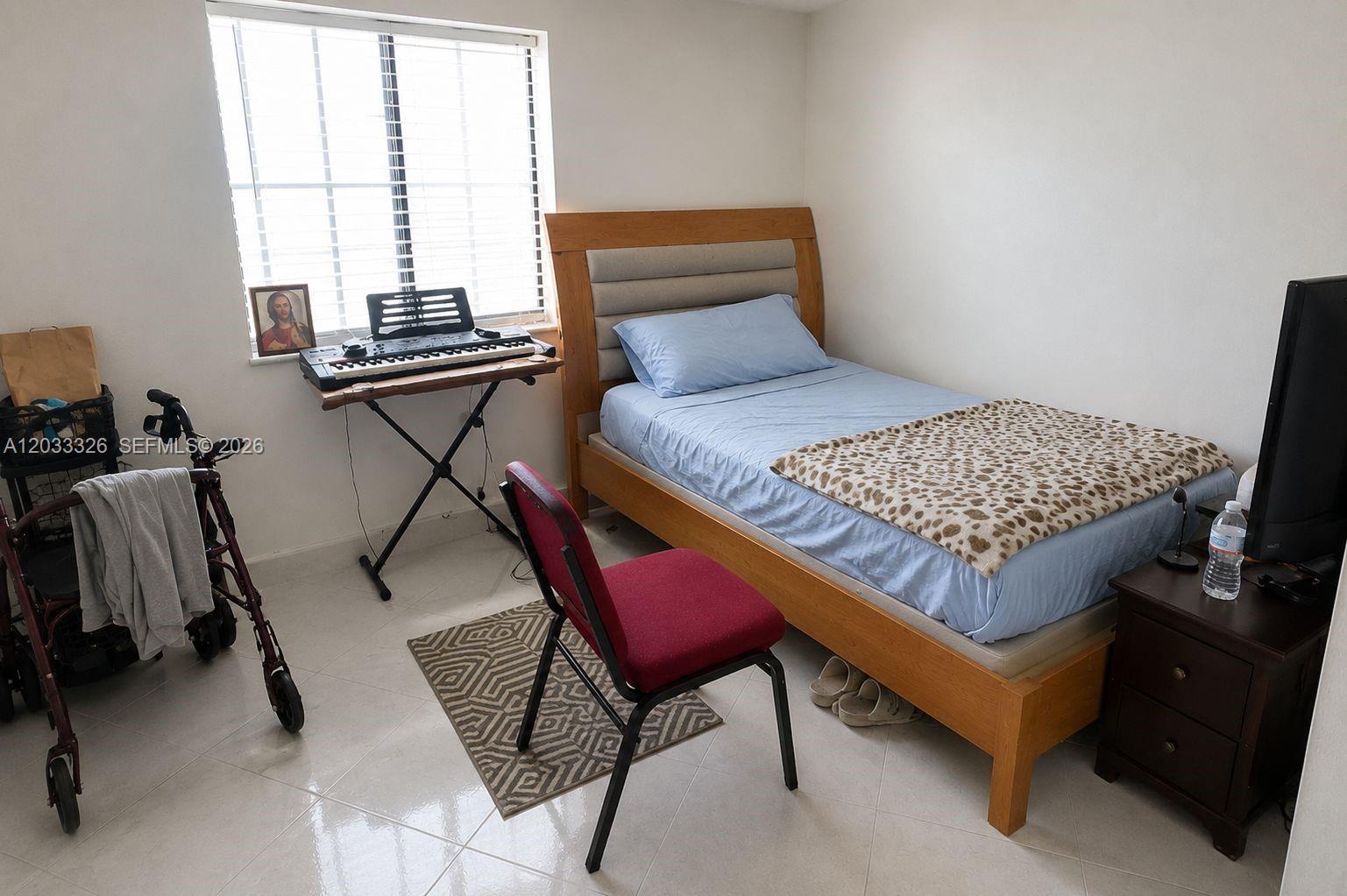 A bedroom features a single bed, a keyboard on a stand, and a mobility walker — 6215 W 22nd Ct # 15, Hialeah FL 33016, HIALEAH, FL