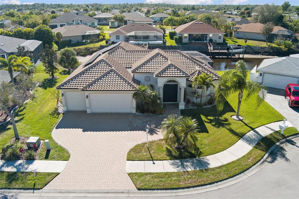 An aerial view shows a single-story house with a tiled roof, driveway, and palm trees — 6557 LINO ROAD, NORTH PORT, FL