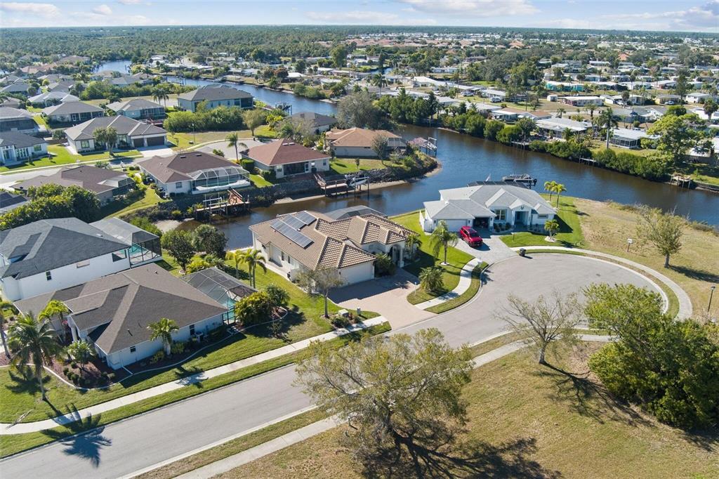 An aerial view shows suburban houses with swimming pools situated along a winding canal — 6557 LINO ROAD, NORTH PORT, FL