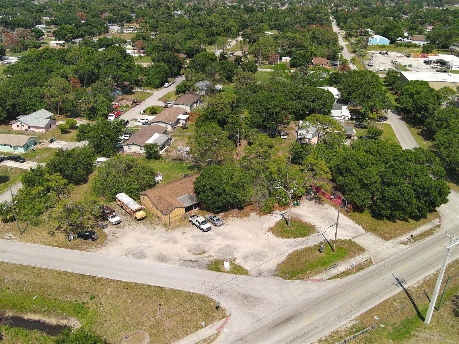 An aerial view shows a residential property with a large gravel lot and school bus — 902 Angle Road, Fort Pierce FL 34947, FORT PIERCE, FL
