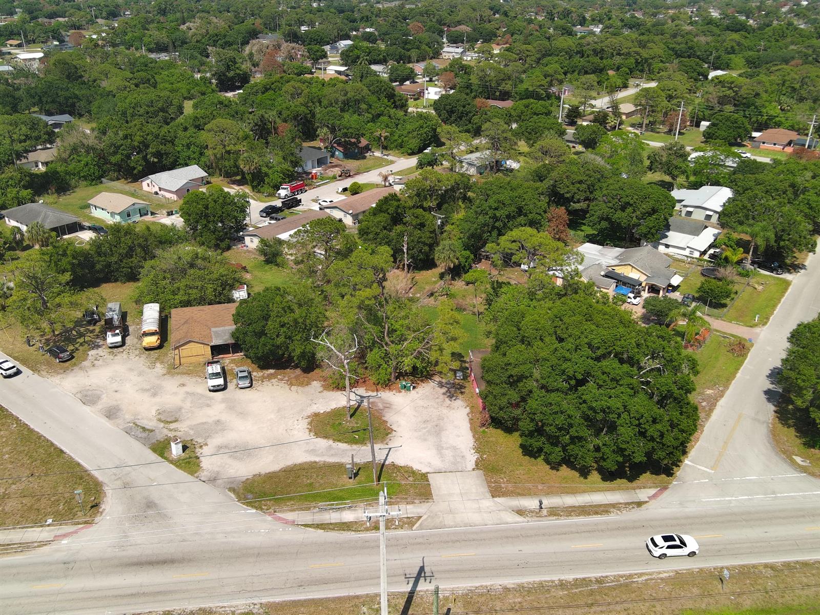 An aerial view shows a gravel lot with several vehicles and a building near a road — 902 Angle Road, Fort Pierce FL 34947, FORT PIERCE, FL