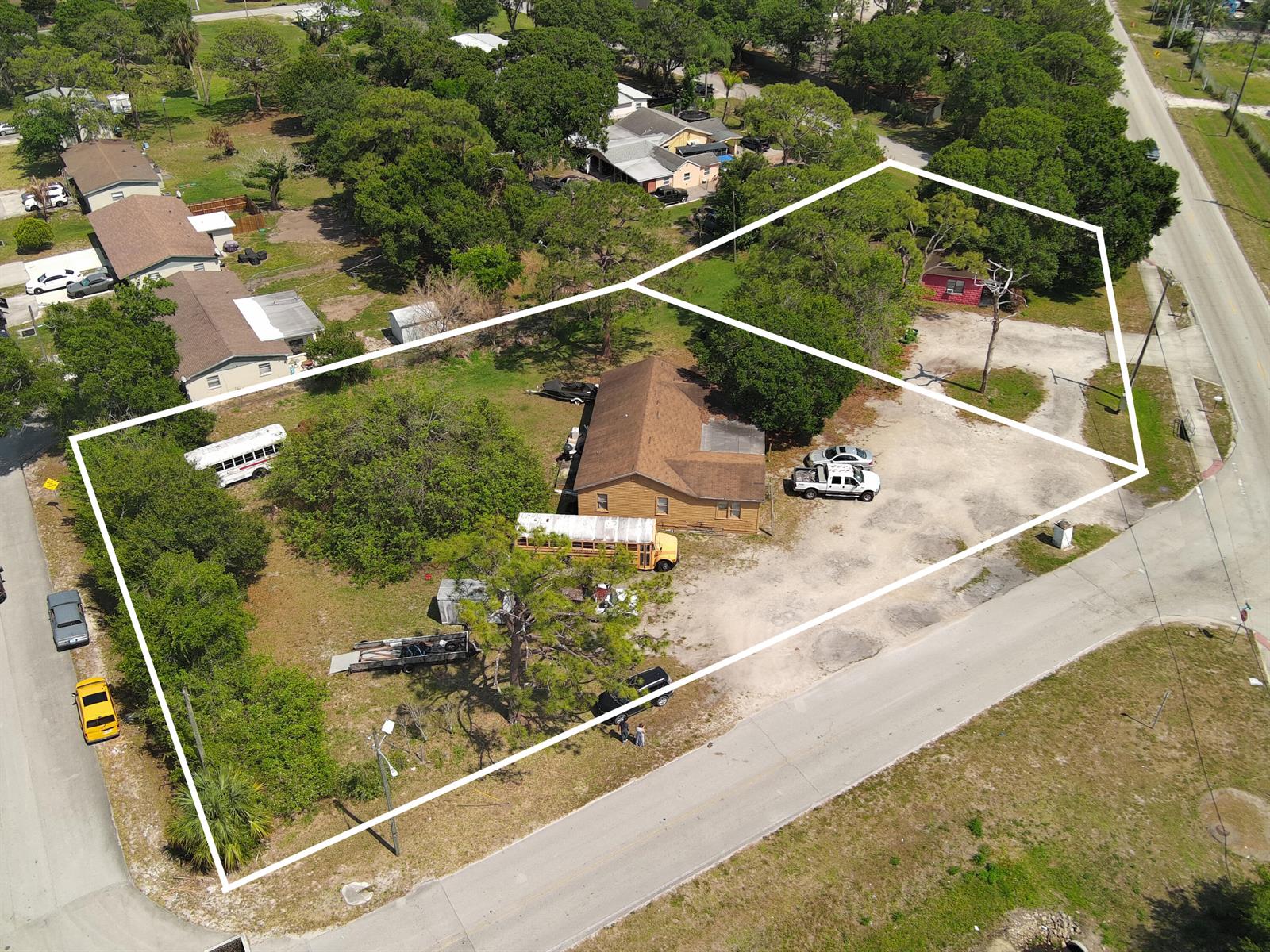 An aerial view shows two adjacent lots with a house, school buses, and vehicles — 902 Angle Road, Fort Pierce FL 34947, FORT PIERCE, FL
