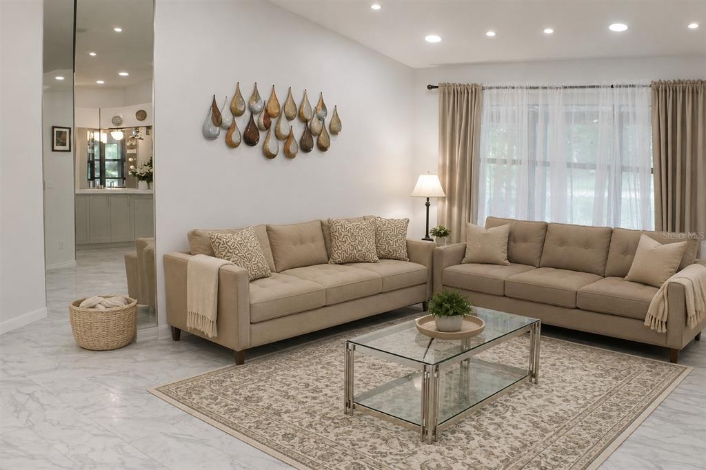 A living room features two beige sofas, a glass coffee table, and wall-mounted teardrop decor — 1723 BELL RANCH STREET, BRANDON, FL