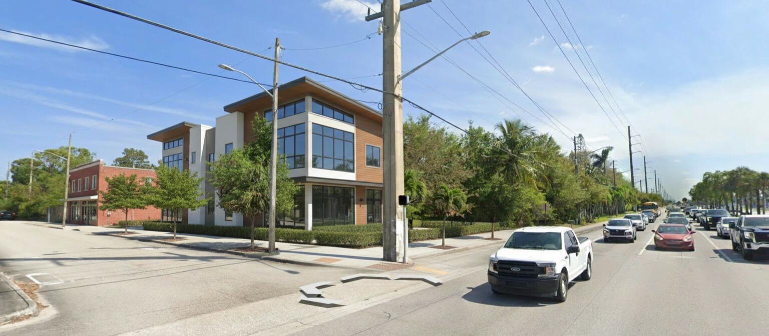 A modern two-story building with wood siding and large windows sits on a street corner — 4390 S Jog Road, FL 33463, FL