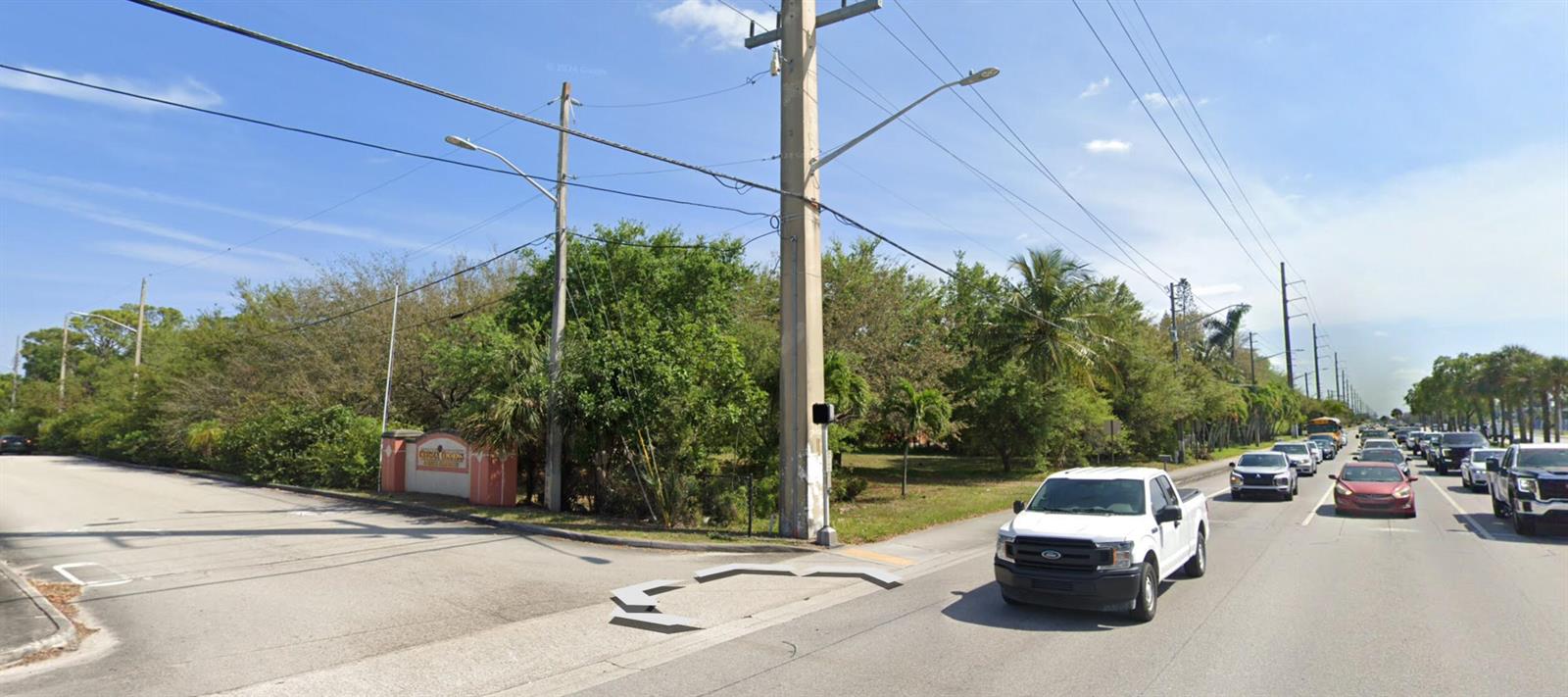 A view of a street corner with a white pickup truck and a wooded lot — 4390 S Jog Road, FL 33463, FL