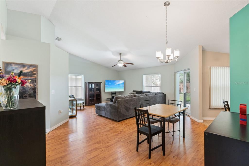 A living and dining area with wood-look flooring, a gray sectional, and a ceiling fan — 319 STERLING LAKE DRIVE, OCOEE, FL