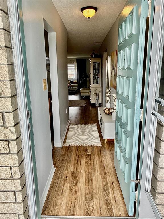 A white storm door with a glass panel is set into a light-colored brick wall — 5357 81ST STREET N UNIT 15, ST PETERSBURG, FL