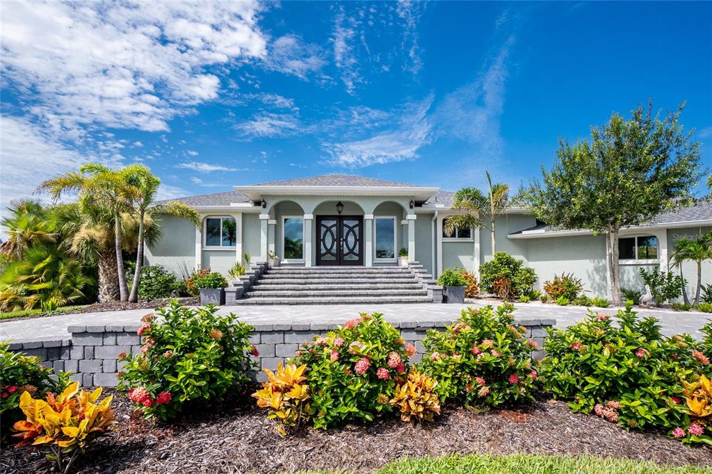 The exterior of a light green house features a wide staircase leading to double doors — 600 LOOKOUT ALLEY, PLACIDA, FL