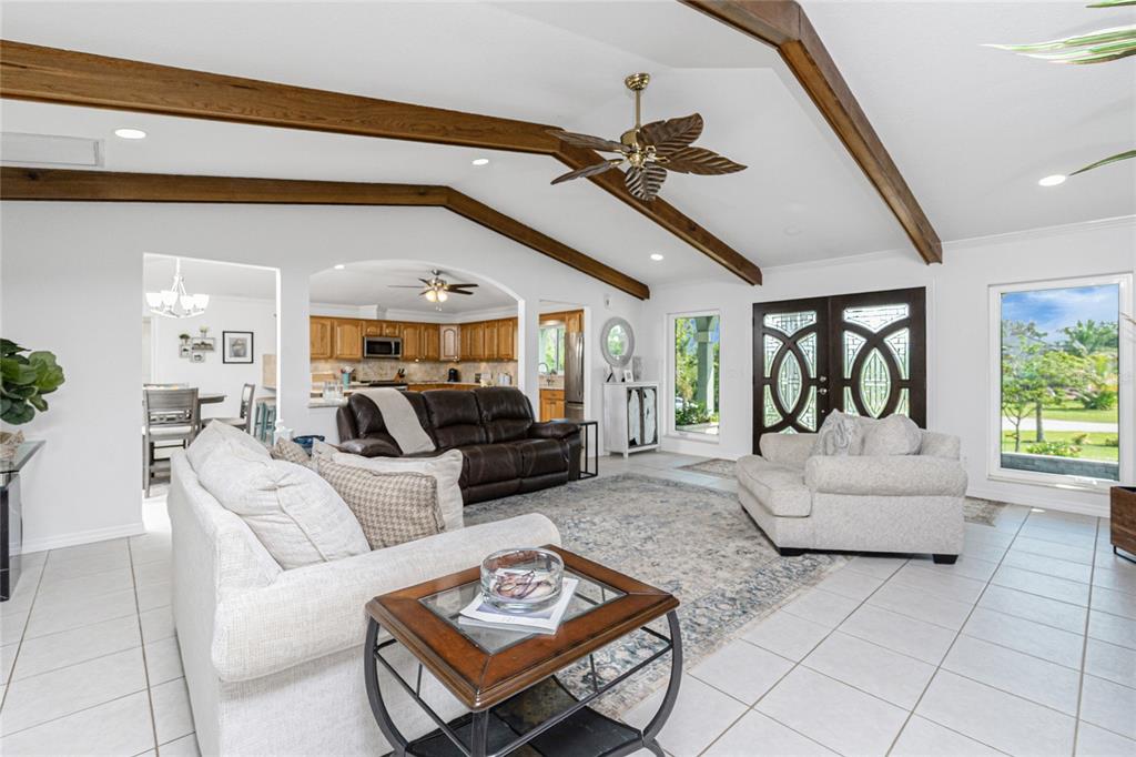 A living room with vaulted ceilings, exposed wooden beams, tile floors, and a ceiling fan — 600 LOOKOUT ALLEY, PLACIDA, FL