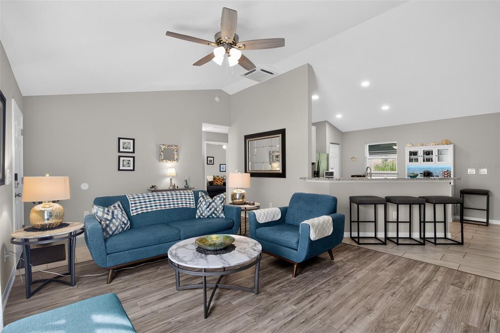 A living room with a blue sofa, matching armchair, and a marble-topped coffee table — 484 MARION OAKS LANE, OCALA, FL