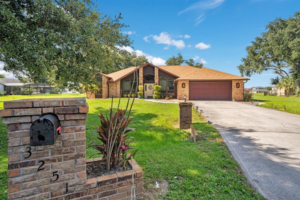 A brick house with a large driveway and a brick mailbox in the front yard — 3251 PINEWOOD COURT, KISSIMMEE, FL