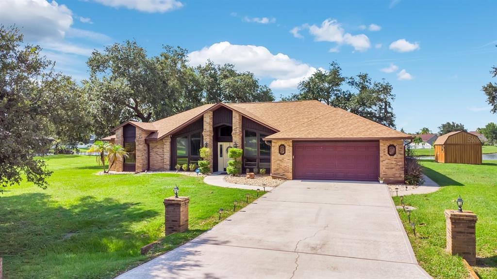A single-story brick house with a brown shingled roof and a concrete driveway — 3251 PINEWOOD COURT, KISSIMMEE, FL