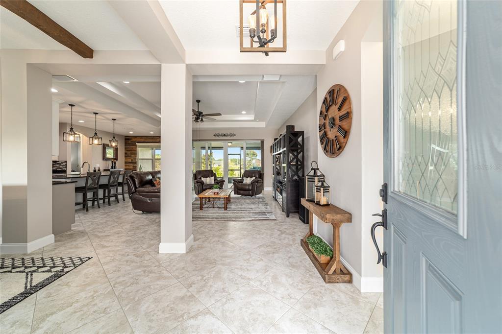 An open-concept home interior features a tiled entryway, living area, and kitchen with pendant lighting — 1983 NW 79TH LOOP, OCALA, FL