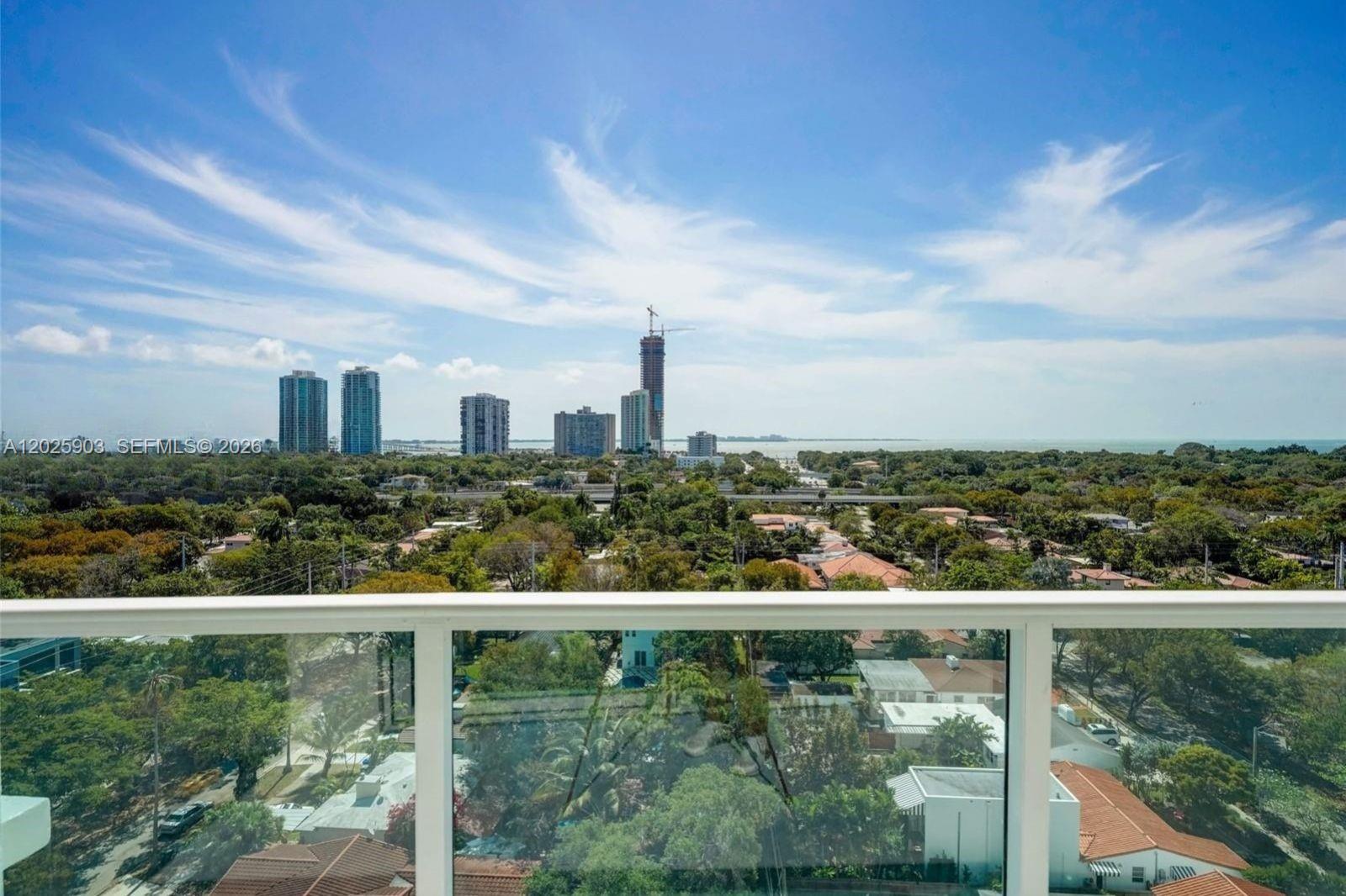 A high-angle view from a balcony overlooking a suburban neighborhood and distant city skyline — 2525 SW 3rd Ave # 1009, Miami FL 33129, MIAMI, FL