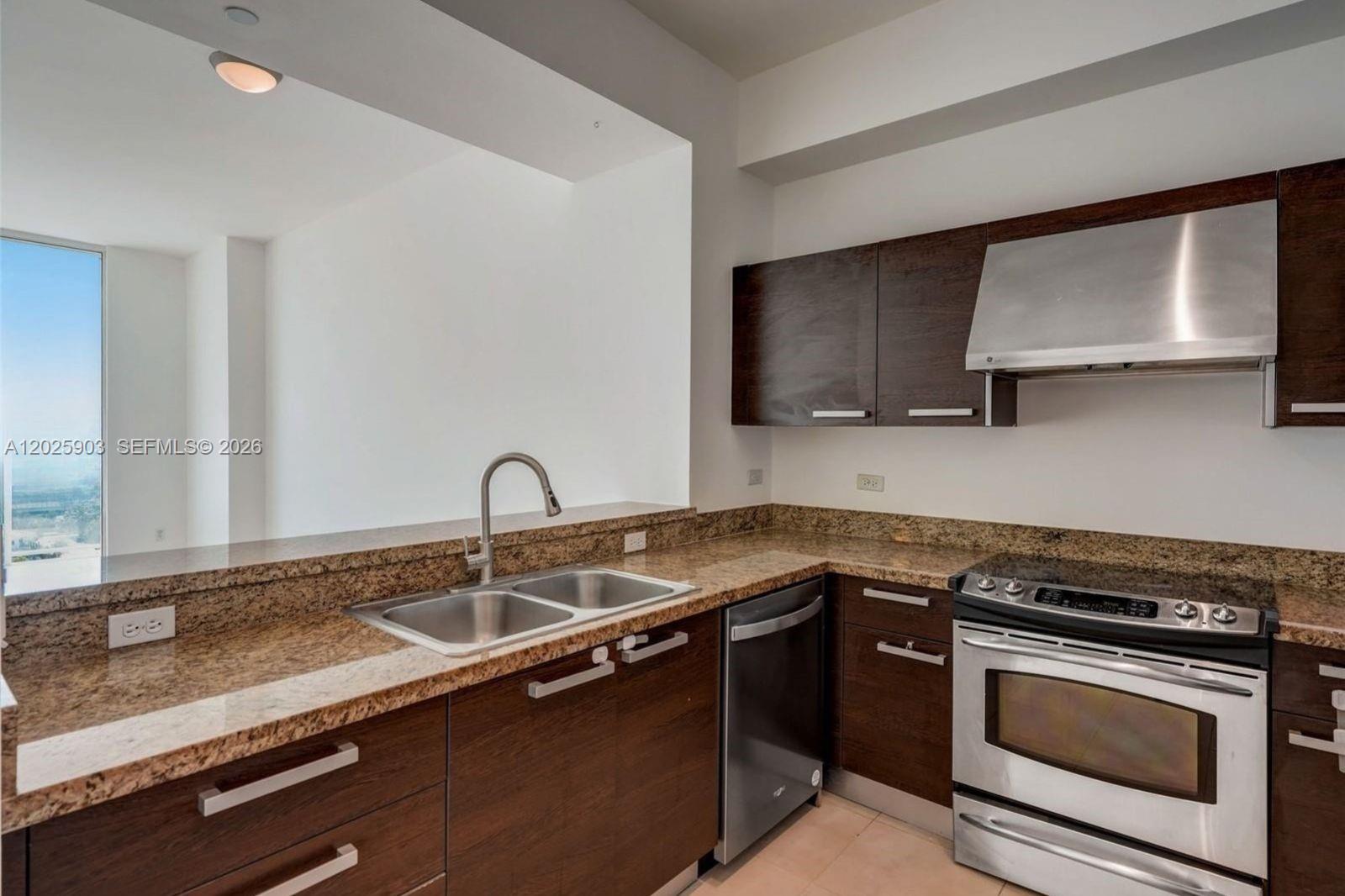 A kitchen features dark wood cabinets, granite countertops, stainless steel appliances, and a double sink — 2525 SW 3rd Ave # 1009, Miami FL 33129, MIAMI, FL