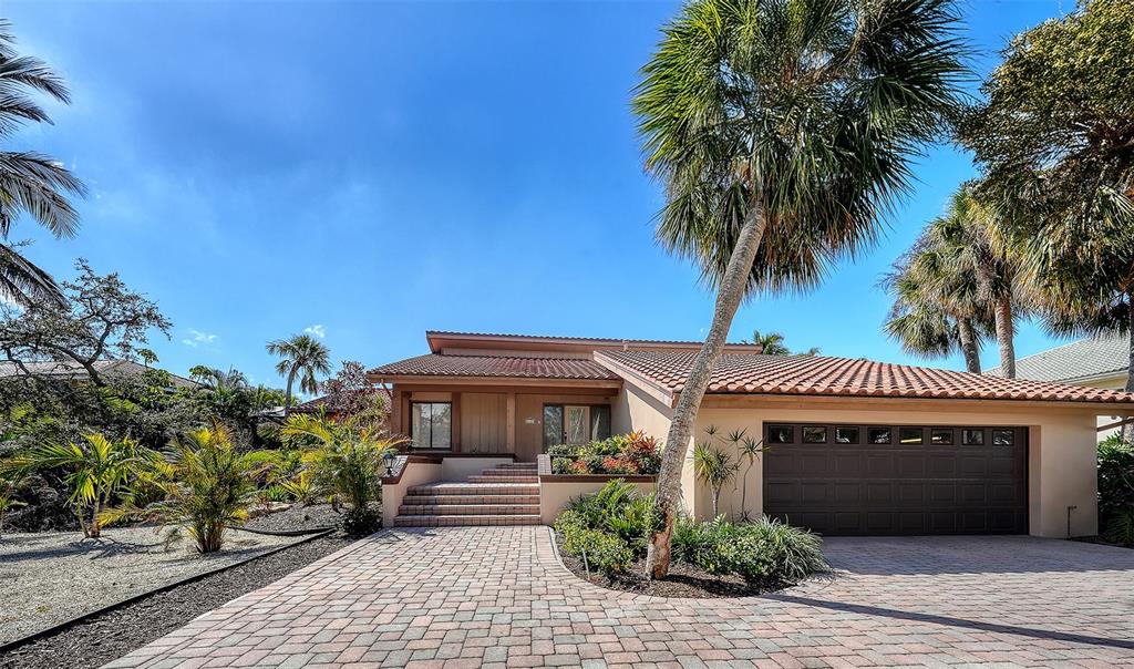 A single-story house with a tiled roof, a paved driveway, and palm trees — 3131 BAYOU SOUND, LONGBOAT KEY, FL