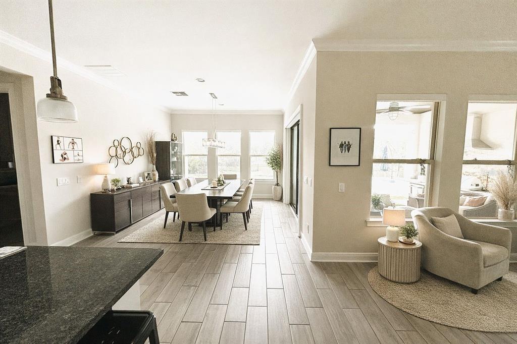 An open-concept dining area features a dark wood table, upholstered chairs, and tile flooring — 3191 PLAYERS VIEW CIRCLE, LONGWOOD, FL