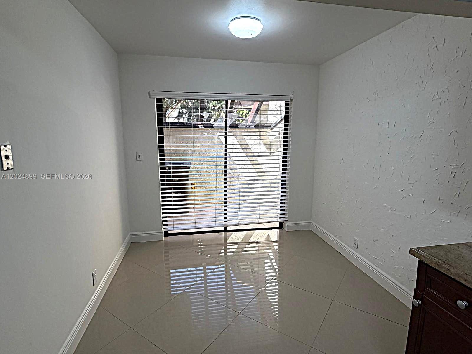 A dining area features tiled floors, white walls, and sliding glass doors with blinds — 6620 Tiburon Cir # 3, Boca Raton FL 33433, BOCA RATON, FL