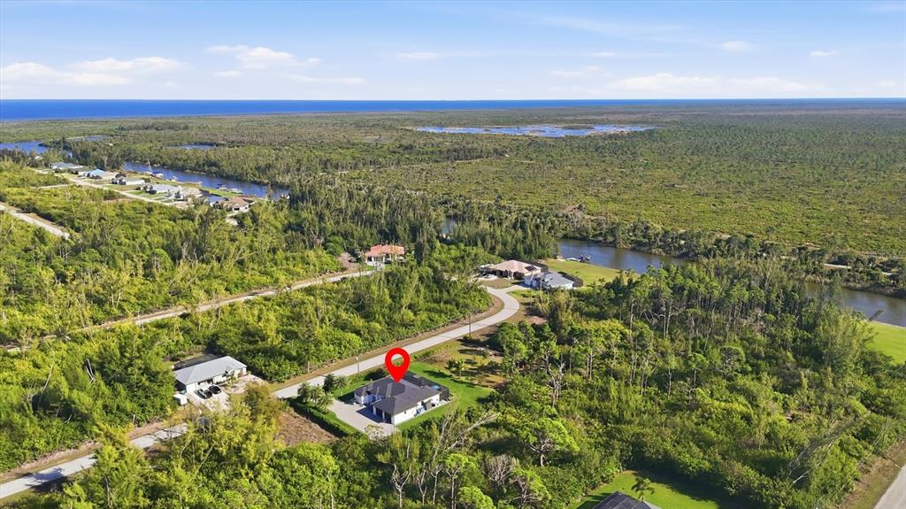 An aerial view shows a house with a red location pin in a wooded area — 10726 KEARSARGE CIRCLE, PORT CHARLOTTE, FL