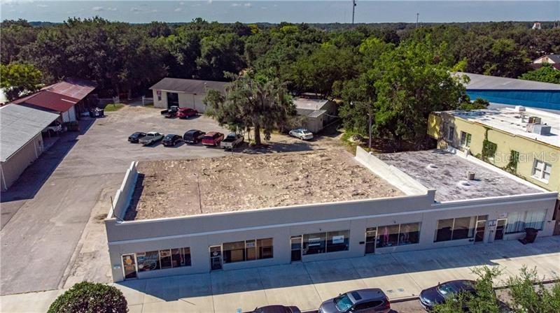 An aerial view shows a commercial building with a flat roof and adjacent parking lot — 1219 W MAIN STREET, LEESBURG, FL