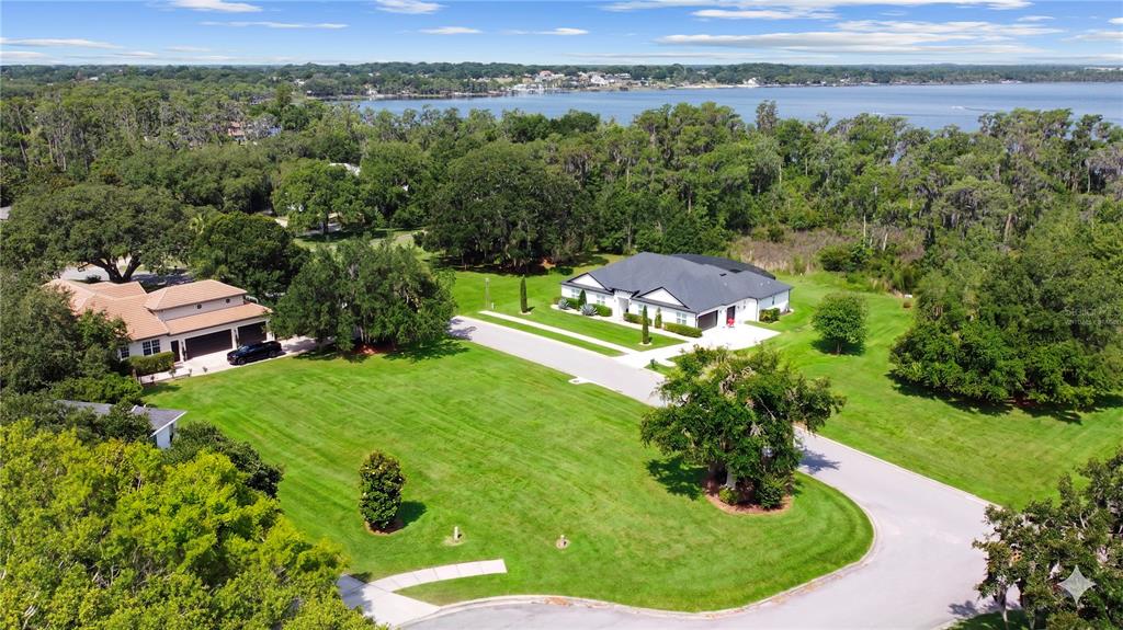 An aerial view shows a house with a dark roof situated on a large grassy lot — Lot 47 OSPREY POINTE BOULEVARD, CLERMONT, FL