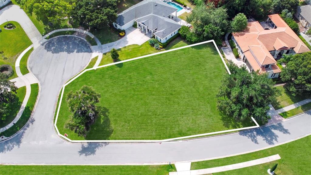 An aerial view shows a vacant, grassy residential lot outlined in white within a neighborhood — Lot 47 OSPREY POINTE BOULEVARD, CLERMONT, FL