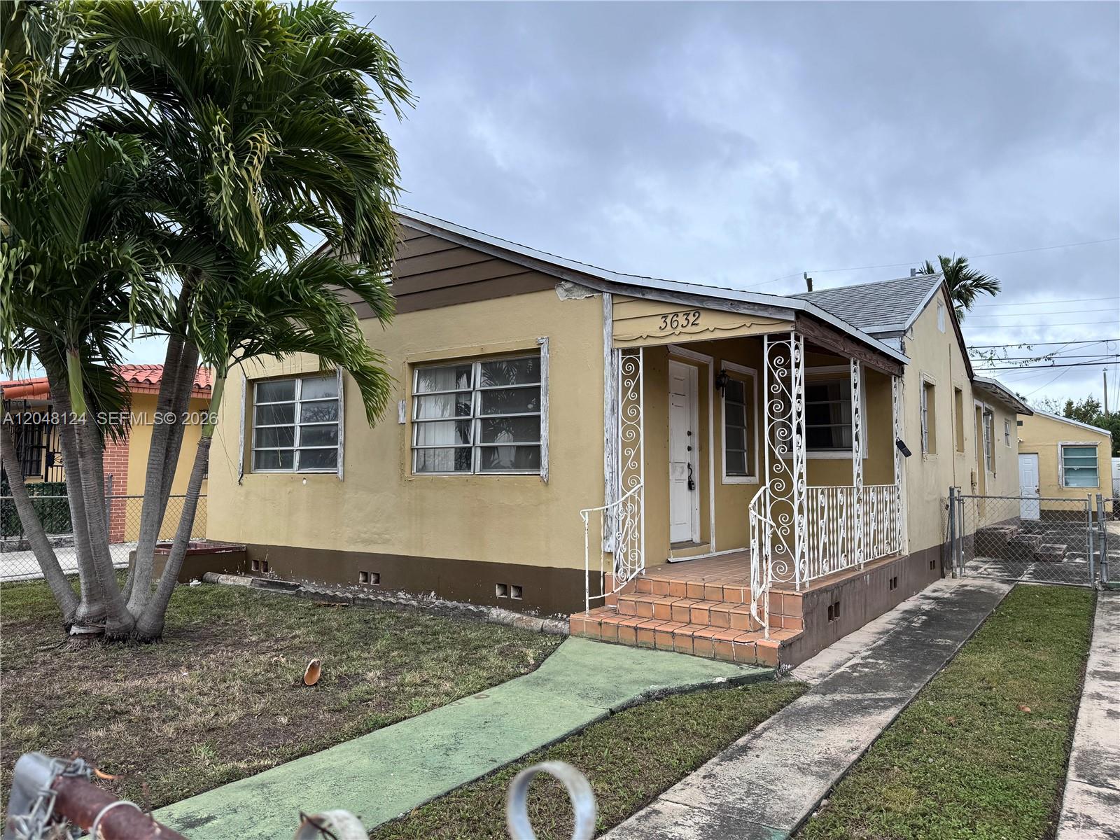 A single-story yellow house features a front porch with white decorative metal railings — 3632 SW 25th St, Miami FL 33133, MIAMI, FL