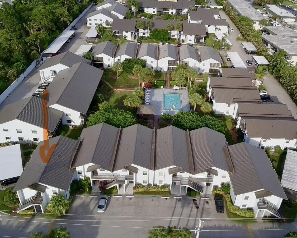 An aerial view of a multi-unit residential complex with a central swimming pool and parking — 1811 SW Palm City Road # A602, Stuart FL 34994, STUART, FL