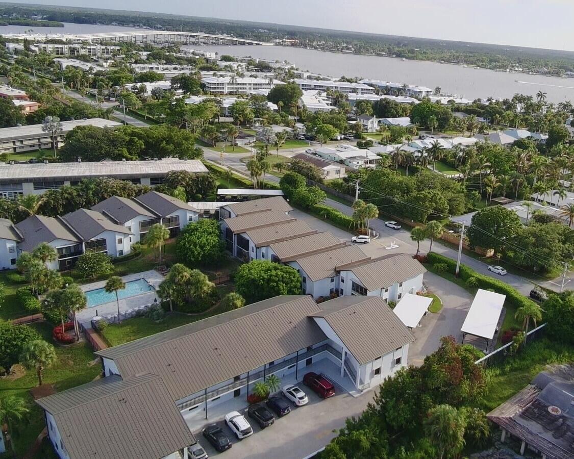 An aerial view shows a multi-building apartment complex with a swimming pool and parking lot — 1811 SW Palm City Road # A602, Stuart FL 34994, STUART, FL