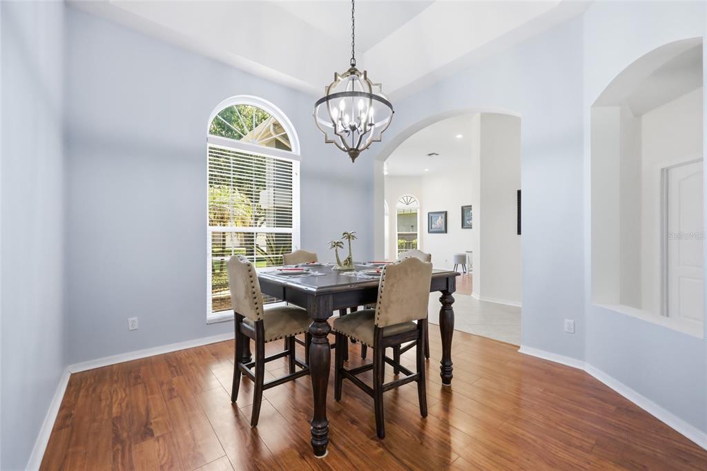 A dining room features a dark wood table, upholstered chairs, a chandelier, and hardwood floors — 3661 CRESCENT PARK BOULEVARD, ORLANDO, FL