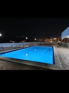 An illuminated rectangular swimming pool is set on a concrete deck at night — 2950 SW 3rd Ave # 3A, Miami FL 33129, MIAMI, FL