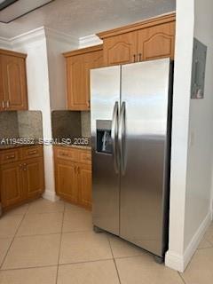 A stainless steel side-by-side refrigerator stands in a kitchen with wood cabinets and tile floors — 2950 SW 3rd Ave # 3A, Miami FL 33129, MIAMI, FL