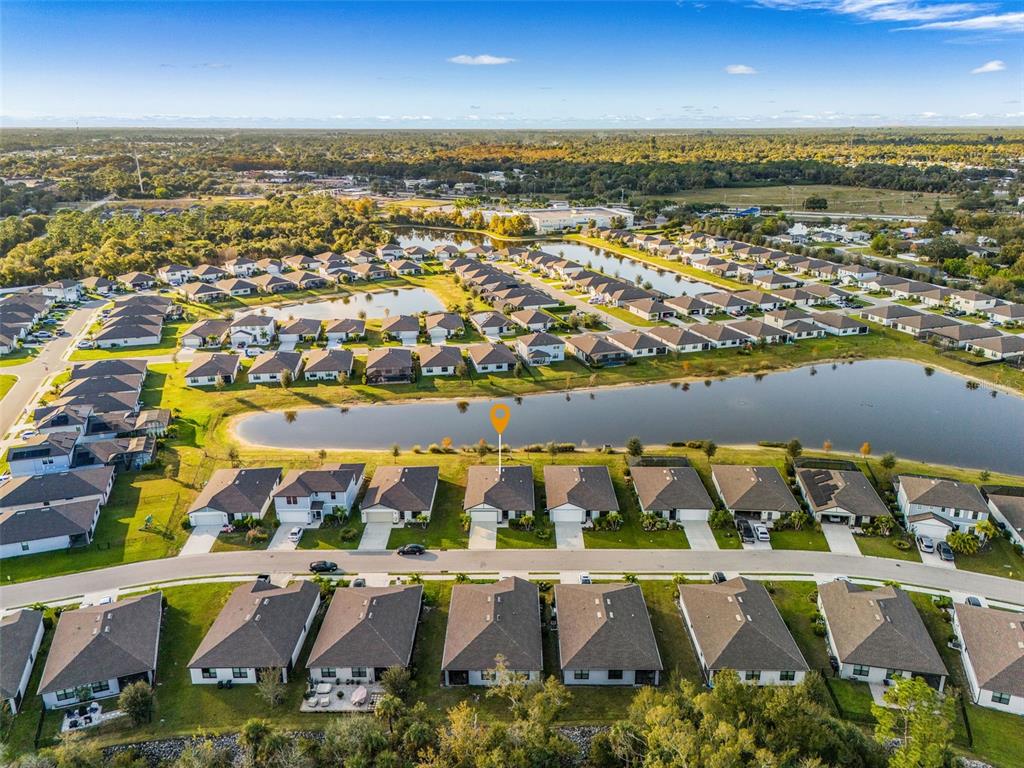 An aerial view shows a suburban neighborhood with houses surrounding several retention ponds — 16033 BEACHBERRY DRIVE, NORTH FORT MYERS, FL